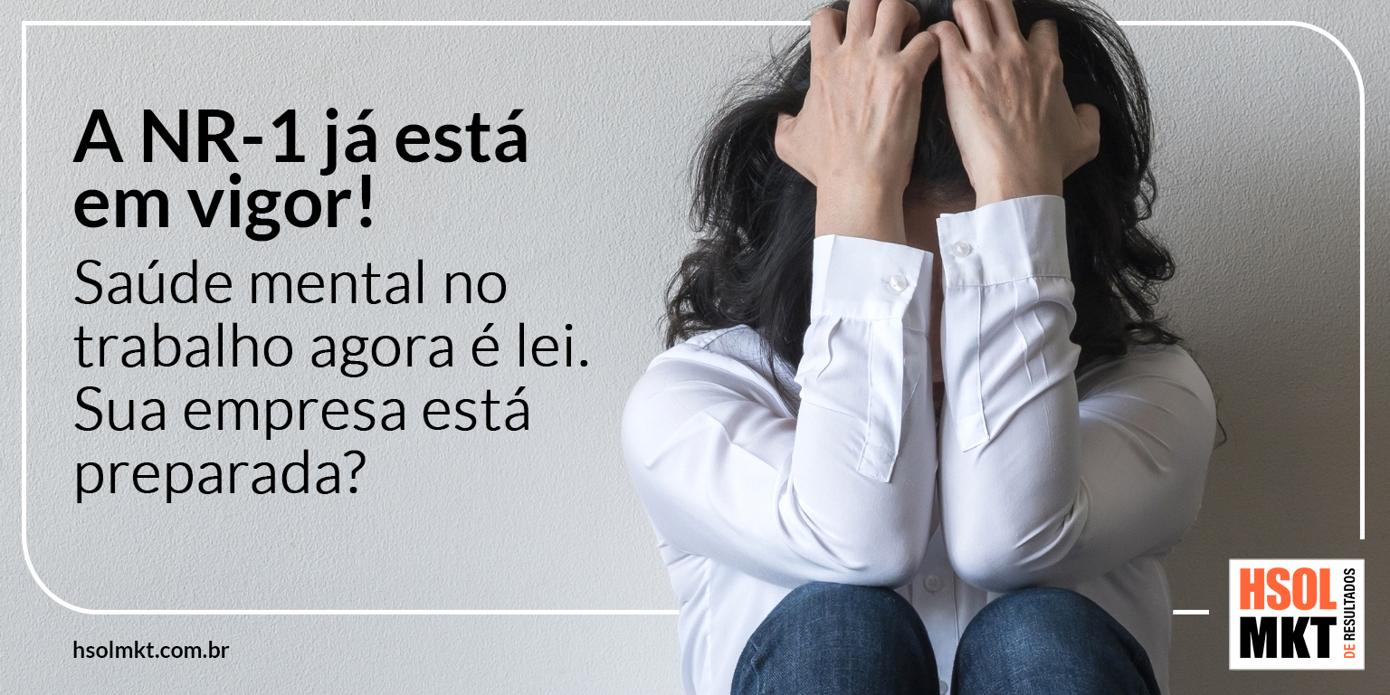 Profissional sobrecarregada segurando a cabeça — nova NR-1 exige gestão de saúde mental nas empresas.